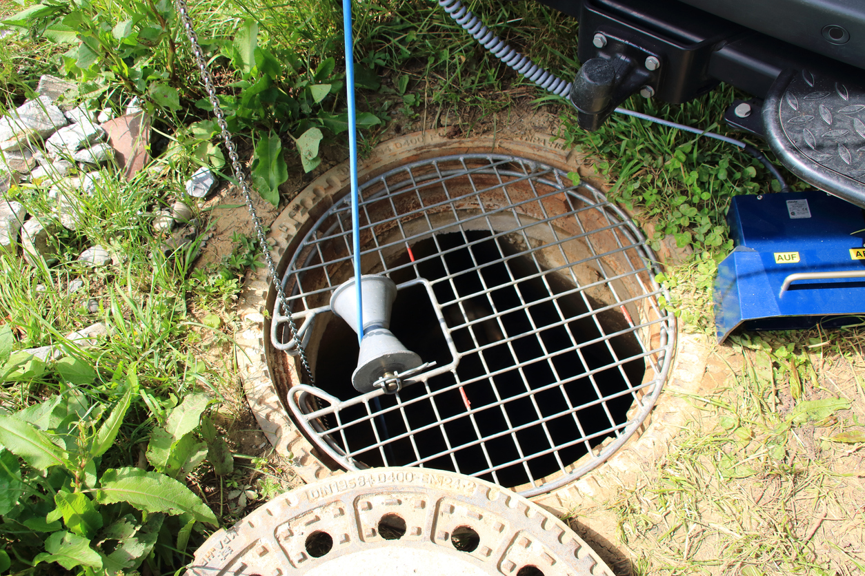 A grate over a manhole in a yard, during sewer line repair