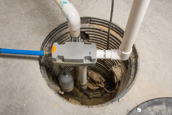 A sewage ejector pump installed in a concrete floor.